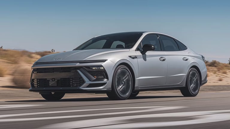 Silver Kia EV9 electric SUV driving on highway with desert landscape in background