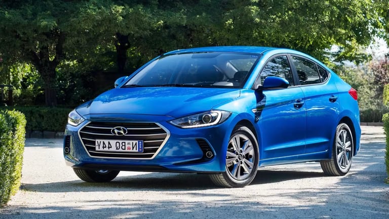 Blue Hyundai Elantra parked on a driveway with green trees in the background